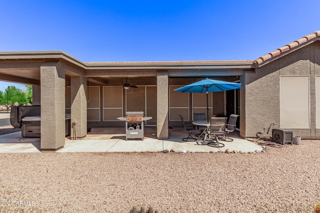 rear view of property featuring ceiling fan and a patio