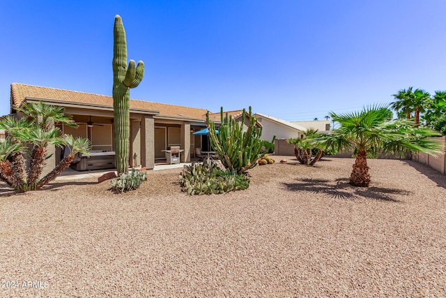 rear view of property featuring ceiling fan and a patio area