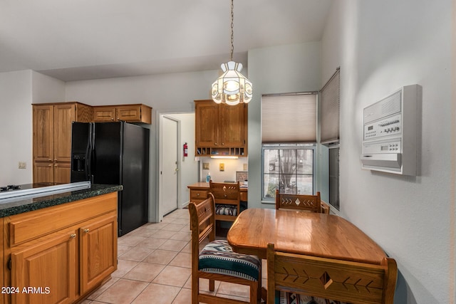 kitchen featuring pendant lighting, light tile patterned floors, and black fridge with ice dispenser