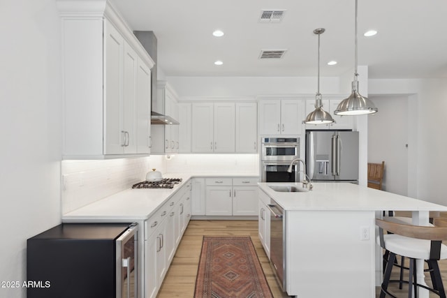 kitchen with stainless steel appliances, hanging light fixtures, light countertops, and white cabinetry