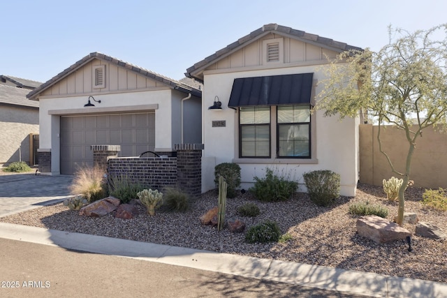 view of front of property with board and batten siding, decorative driveway, a tile roof, and a garage