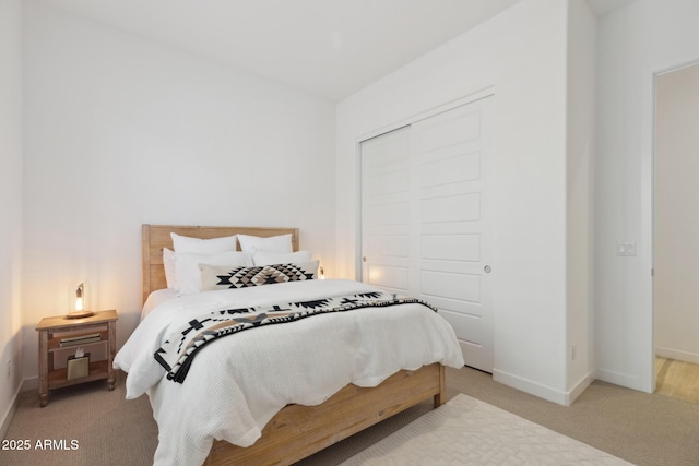 bedroom featuring light carpet, a closet, and baseboards