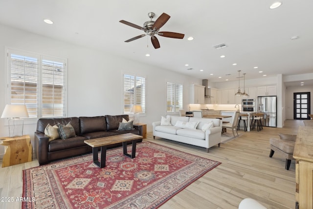 living room featuring light wood-type flooring, recessed lighting, visible vents, and ceiling fan