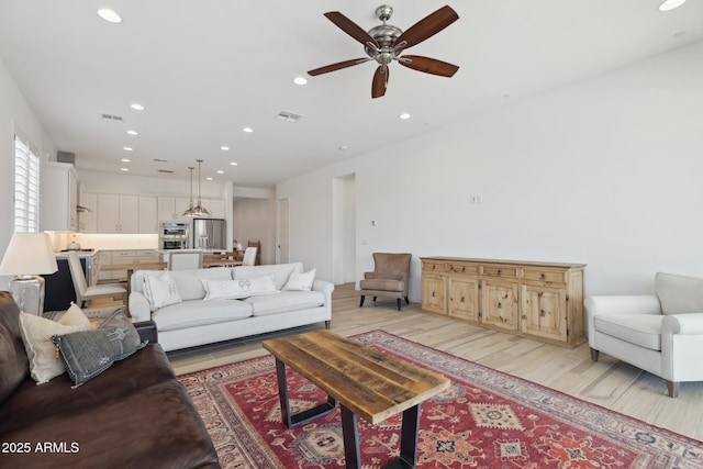 living area featuring recessed lighting, visible vents, and light wood-style flooring