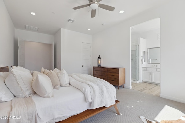 bedroom featuring light colored carpet, recessed lighting, visible vents, and connected bathroom