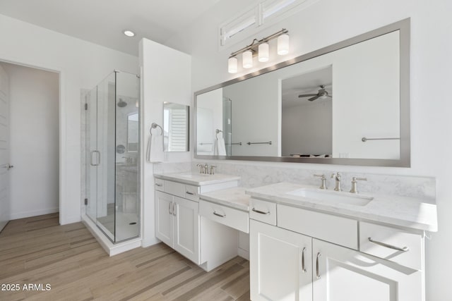 full bath with double vanity, a sink, and wood finished floors