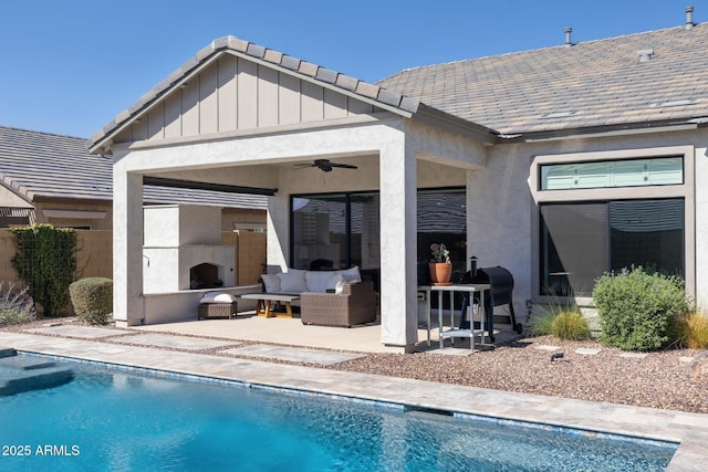 back of house with a patio, stucco siding, an outdoor living space with a fireplace, ceiling fan, and fence