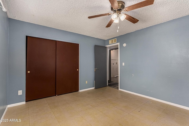 unfurnished bedroom featuring visible vents, baseboards, a closet, a textured ceiling, and a ceiling fan