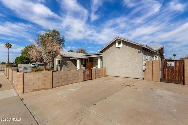 view of front of house with a gate, stucco siding, and a fenced front yard