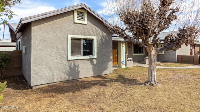 view of front of property featuring fence and stucco siding