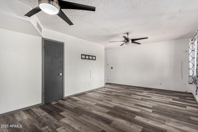 spare room featuring ceiling fan, a textured ceiling, dark wood-style floors, and visible vents