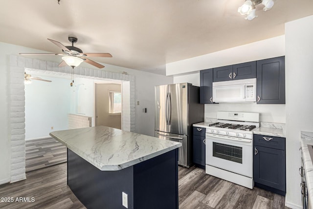 kitchen with ceiling fan, a kitchen island, dark wood-type flooring, and white appliances