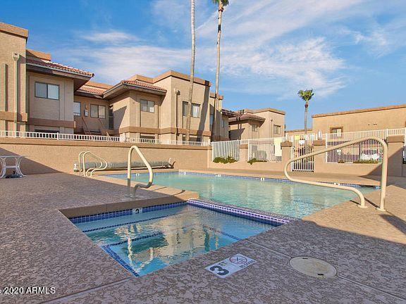 community pool with a residential view, fence, and a patio