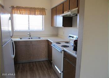 kitchen featuring dark wood-style flooring, freestanding refrigerator, white electric range, under cabinet range hood, and a sink