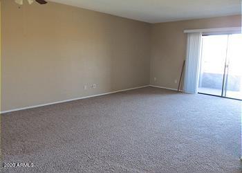 carpeted empty room featuring ceiling fan and baseboards