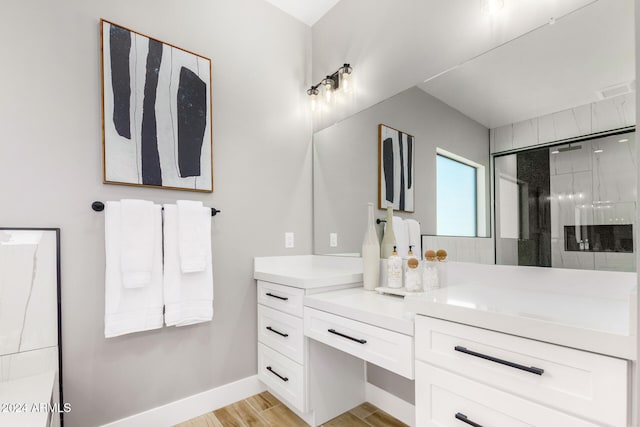 bathroom with hardwood / wood-style floors, vanity, and a shower with door