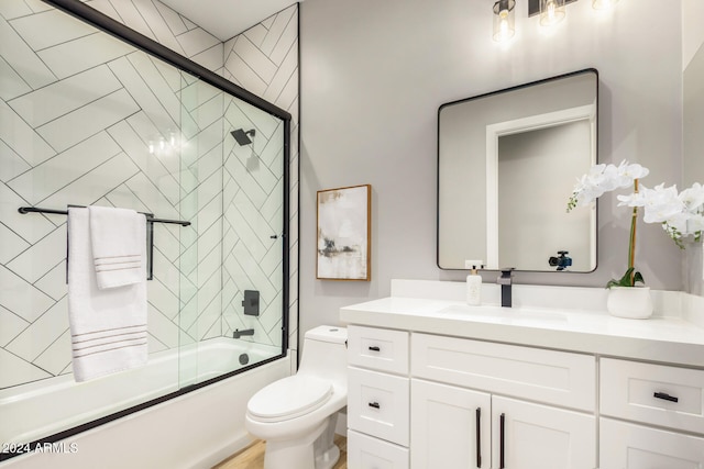 full bathroom with vanity, toilet, and bath / shower combo with glass door