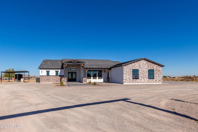 view of front of property featuring french doors and a carport