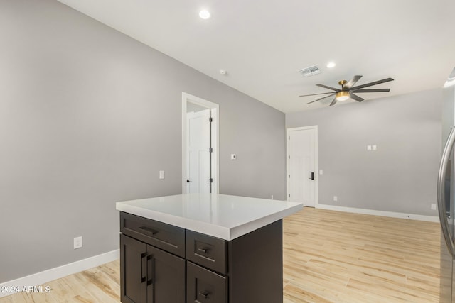 kitchen with ceiling fan, a kitchen island, and light hardwood / wood-style floors