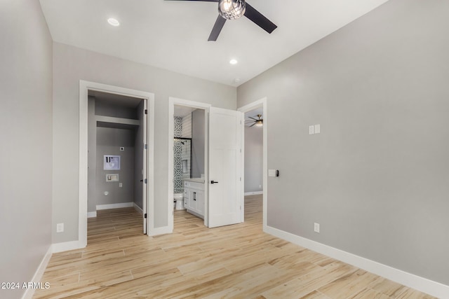 unfurnished bedroom featuring ensuite bathroom, ceiling fan, a walk in closet, and light hardwood / wood-style flooring