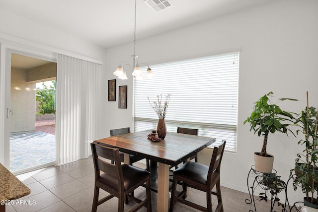 tiled dining room featuring a chandelier