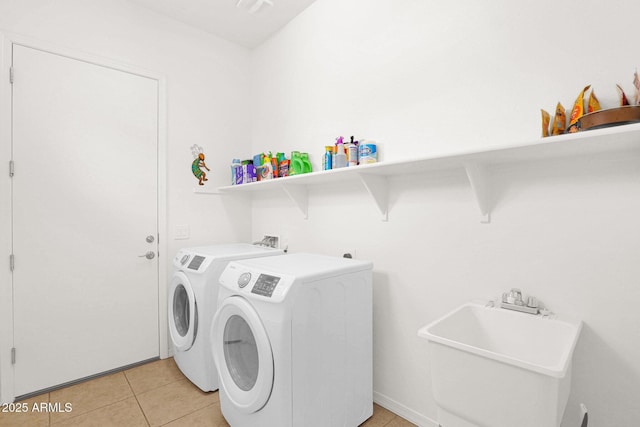 washroom with washer and dryer, sink, and light tile patterned floors