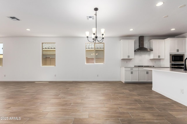 40546 W Michaels Dr, Maricopa, AZ 85138 - kitchen with wall chimney exhaust hood, stainless steel appliances, decorative backsplash, recessed lighting, and light wood-type flooring
