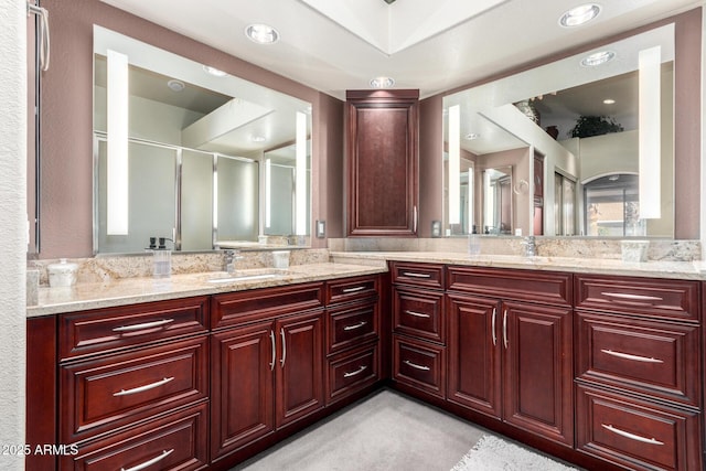 bathroom featuring vanity and a shower with door