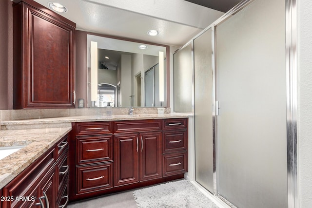 bathroom with a shower with door and vanity