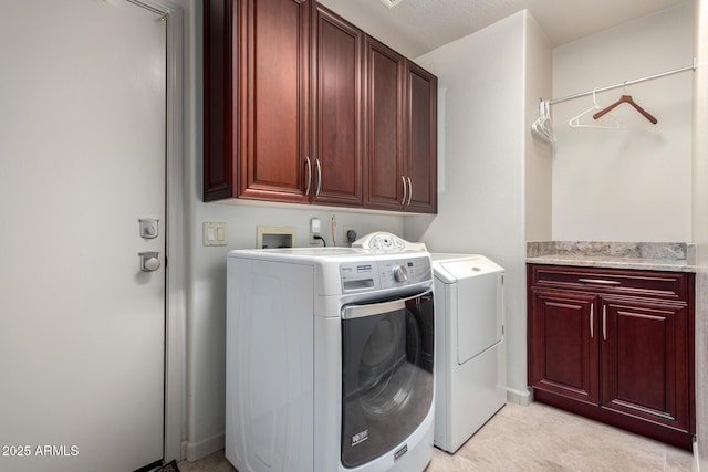 clothes washing area with cabinets and independent washer and dryer