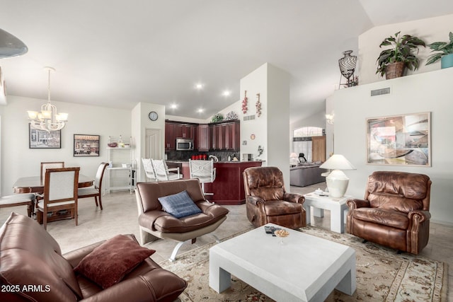 living room featuring high vaulted ceiling and a chandelier