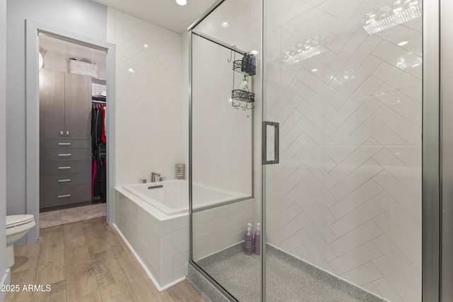 full bath with wood finished floors, a garden tub, and a stall shower