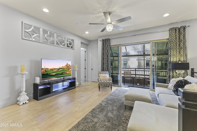 living area with recessed lighting, a ceiling fan, wood finished floors, and baseboards