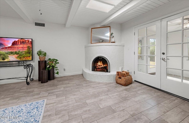 living room featuring beam ceiling, wooden ceiling, and french doors