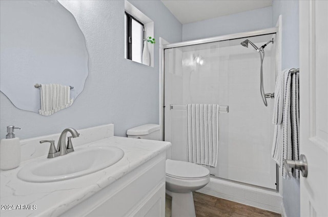 bathroom with vanity, hardwood / wood-style floors, toilet, and an enclosed shower