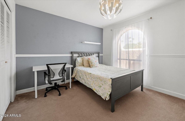 carpeted bedroom with an inviting chandelier and a closet