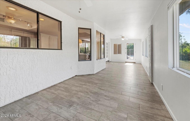 corridor with a healthy amount of sunlight and hardwood / wood-style floors