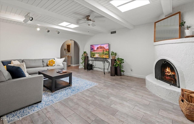 living room with light wood-type flooring, beam ceiling, and ceiling fan