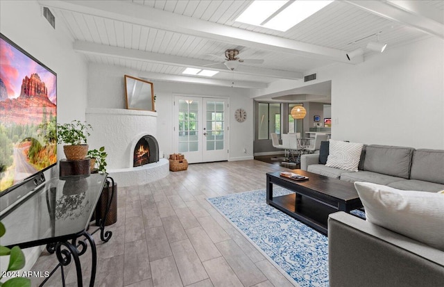 living room with french doors, beam ceiling, light hardwood / wood-style floors, and ceiling fan