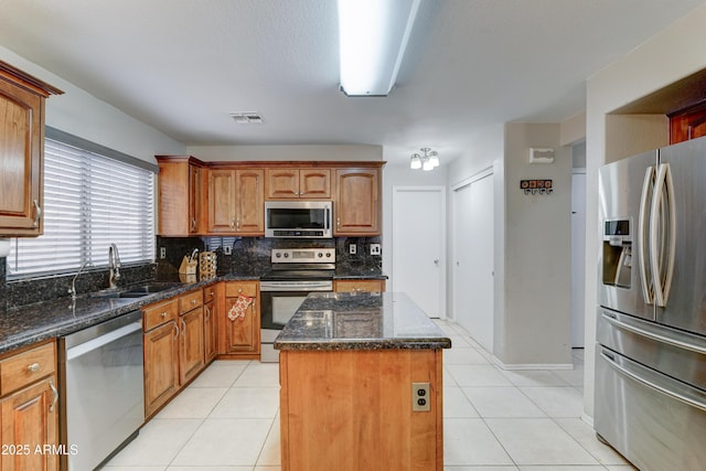 kitchen with visible vents, a sink, a kitchen island, stainless steel appliances, and light tile patterned floors