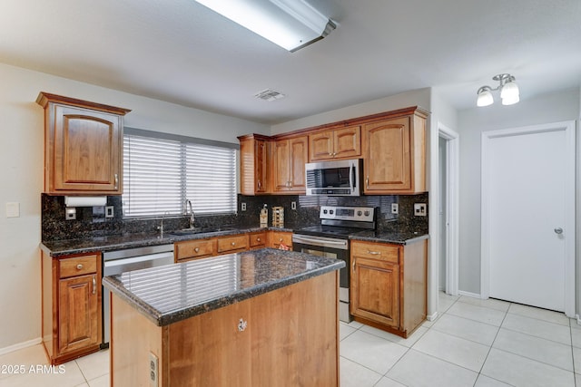 kitchen featuring visible vents, light tile patterned flooring, a sink, appliances with stainless steel finishes, and backsplash