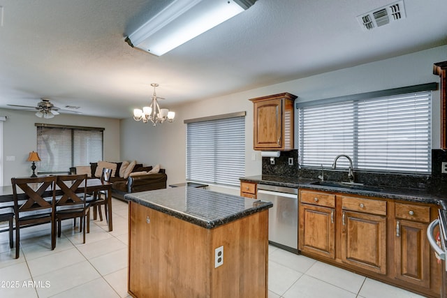 kitchen featuring visible vents, a sink, a kitchen island, stainless steel dishwasher, and light tile patterned floors