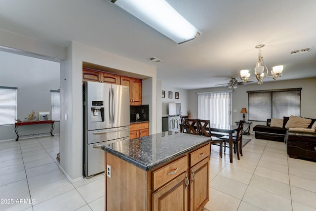 kitchen with light tile patterned flooring, stainless steel fridge with ice dispenser, visible vents, and a chandelier