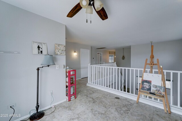 interior space with baseboards and a ceiling fan