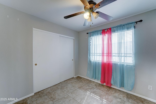 unfurnished bedroom featuring baseboards, a closet, and ceiling fan