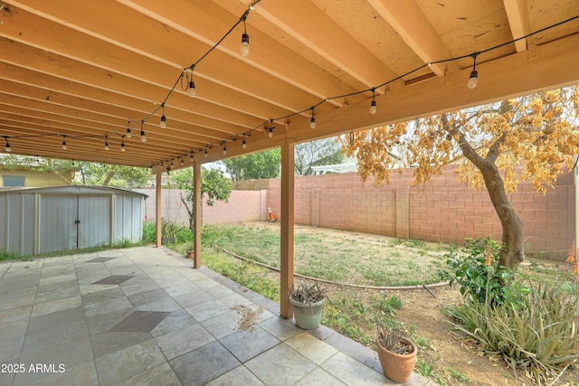 view of patio / terrace featuring a fenced backyard, an outdoor structure, and a shed