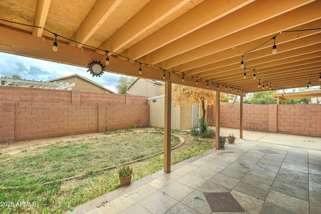 view of patio with an outbuilding and a fenced backyard