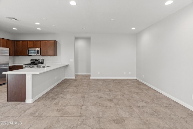 5957 N 89th Dr, Glendale, AZ 85305 - kitchen with stainless steel appliances, recessed lighting, light countertops, a peninsula, and baseboards