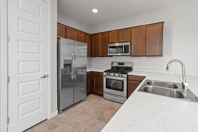 5957 N 89th Dr, Glendale, AZ 85305 - kitchen featuring appliances with stainless steel finishes, a sink, light countertops, brown cabinets, and recessed lighting