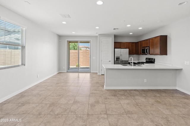 5957 N 89th Dr, Glendale, AZ 85305 - kitchen featuring appliances with stainless steel finishes, a sink, light countertops, a peninsula, and recessed lighting